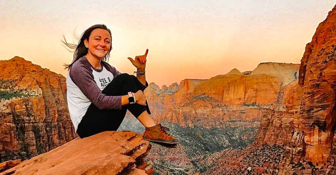 Girl on top of a mountain wearing Xero Shoes