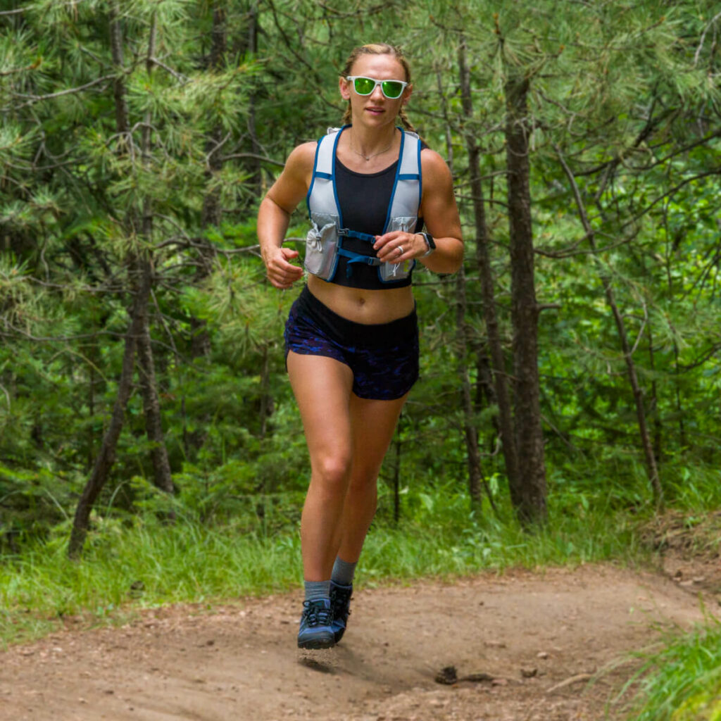 Front view of a woman running on a forest trail