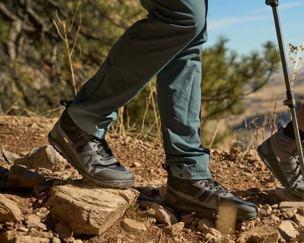 A man hiking outside on a rocky path a cool clear day with his Scrambler Mid II WP boots