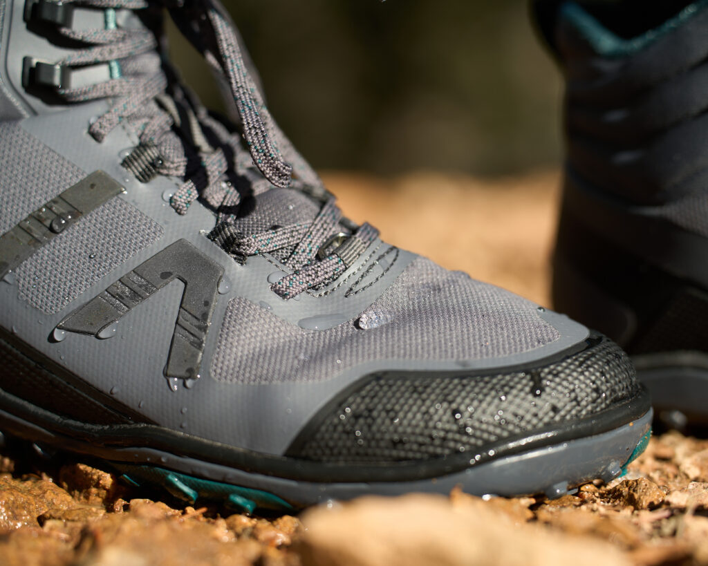 A close up shot of a woman wearing Scrambler Mid II WP boots with water dripping right off the boot